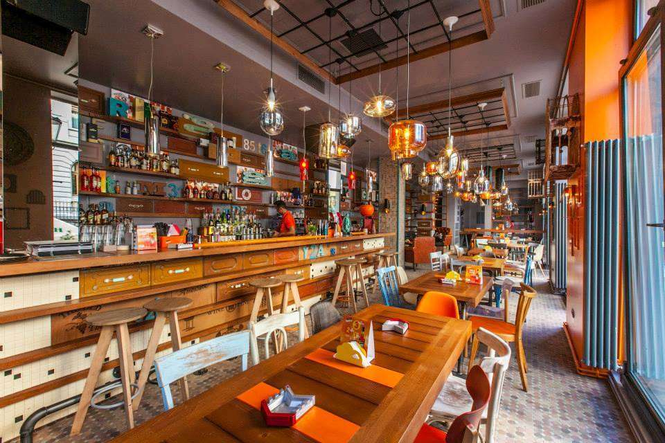 Restaurant Entourage Centrul Vechi, cu mese din lemn, bar si lampi suspendate