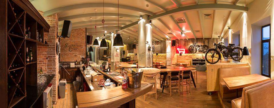 Red Angus Steakhouse, local din Bucuresti cu mese din lemn, canapele si motociclete
