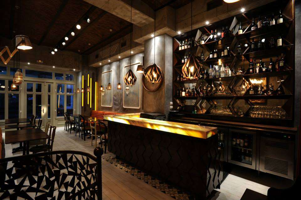 Restaurantul Nouvelle Vague, cu mobilier de culoare inchisa si lumina calda
