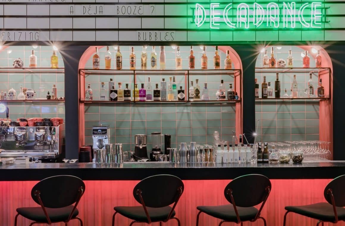 Barul plin cu bauturi de la Decadance Bar, amenajat in nuante de rosu si cu silga luminoasa vere. Cocktail baruri din București