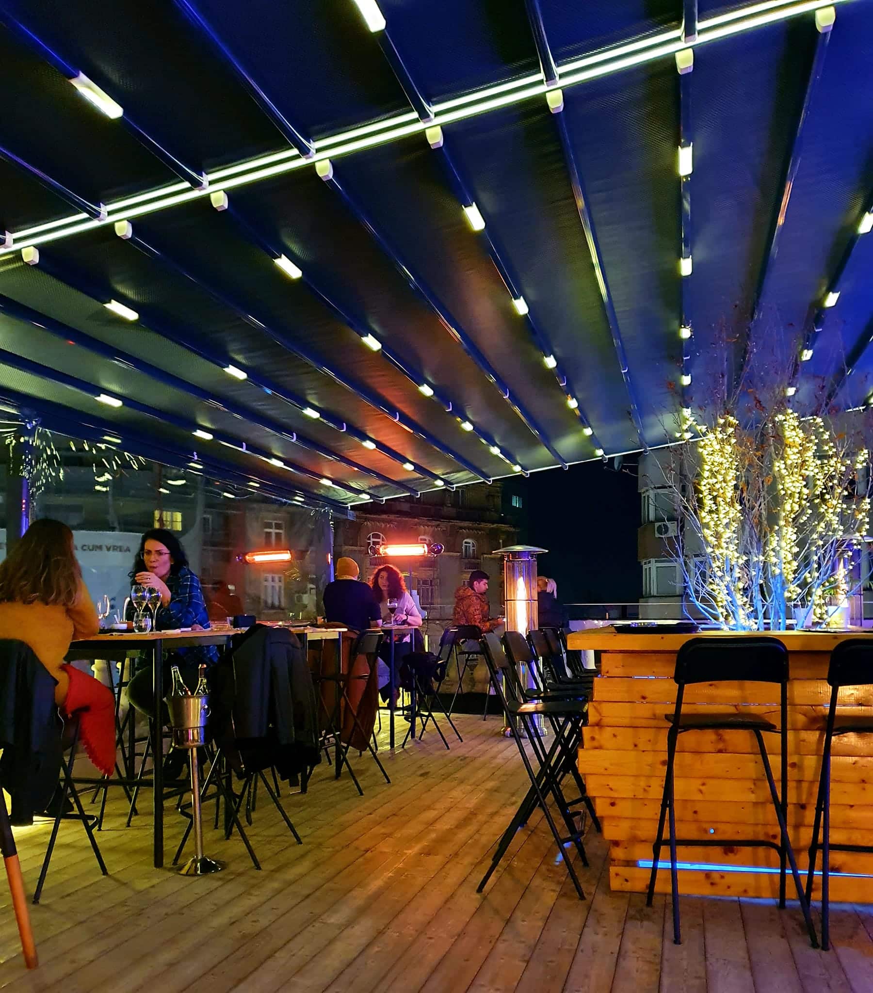 oameni care iau masa pe terasa la Balkon Resto Garden noaptea