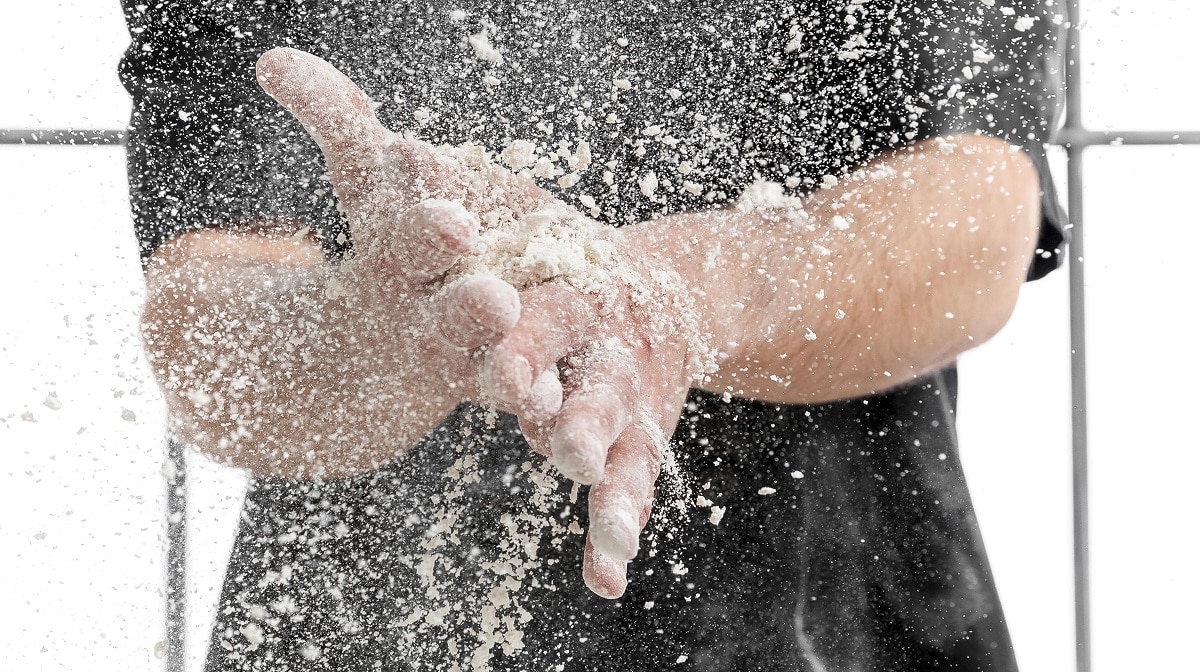 prim plan cu doua maine de copil care se scutura de faina, dupa ce faci pizza cu copiii acasa