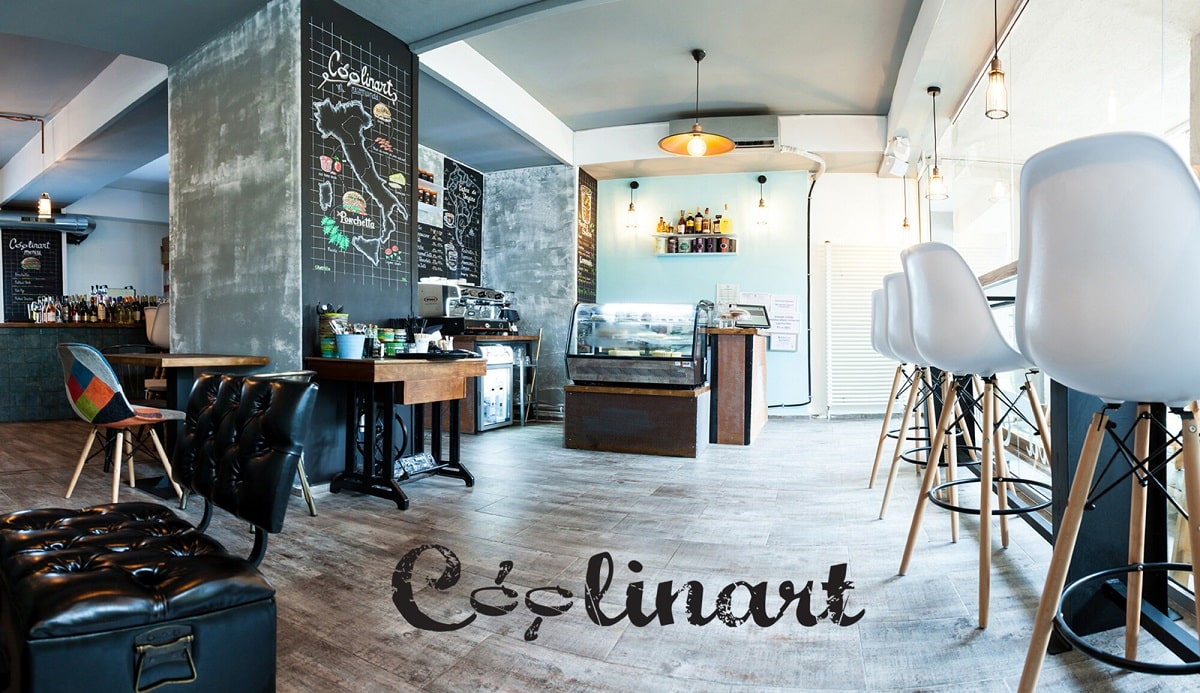 interiorul de la Coolinart, unul din restaurante vegetariene București, cu pereti negri desenati cu creta, mese din lemn si scaune negre