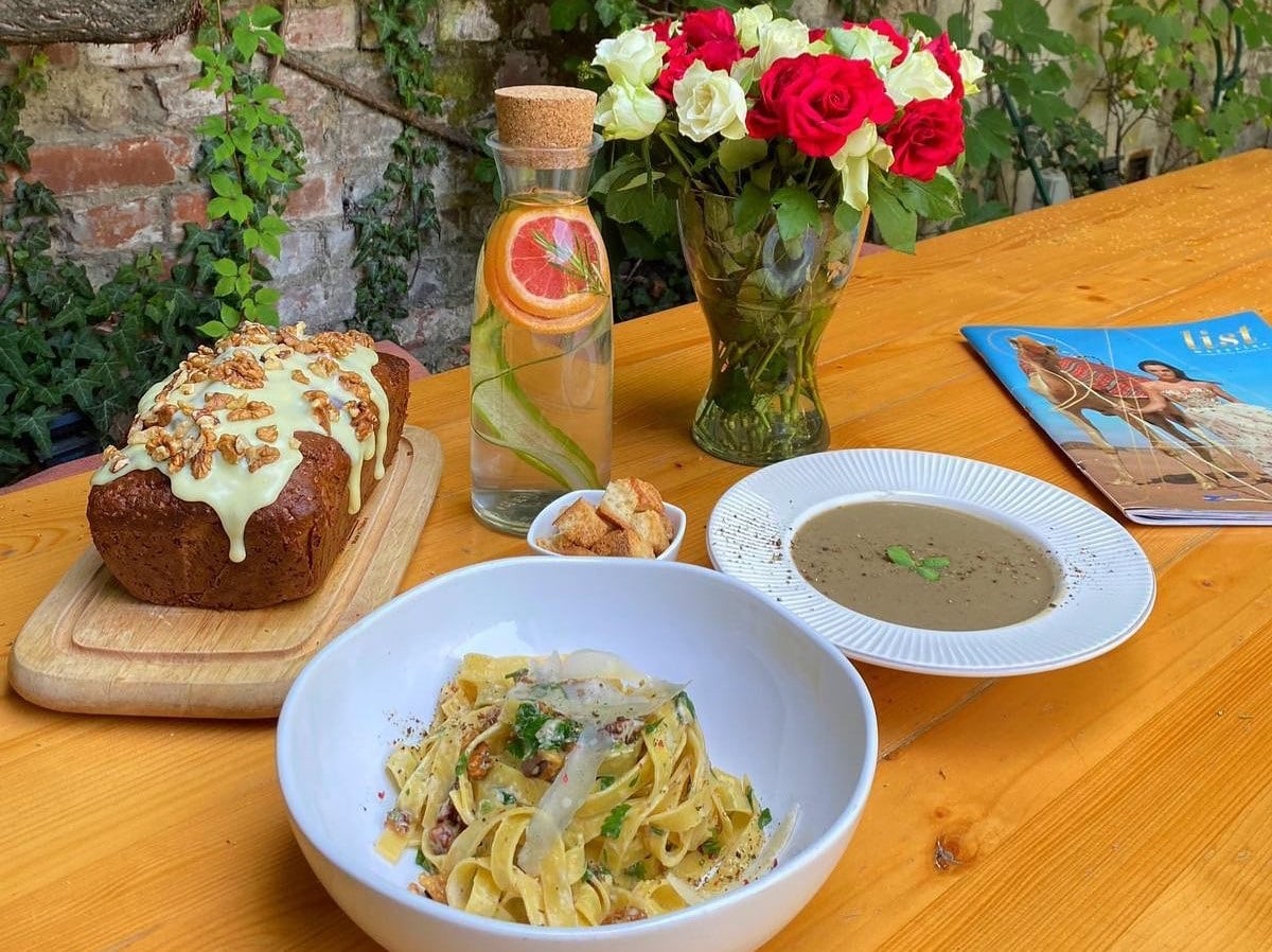 bolalb cu paste, farfurie alba cu supa crema, carafa cu limonada si felii de citrice, vaza cu trandafiri albi si rosii, chec pe tocator de lemn, la Arome si Sunete bUCUREȘTI