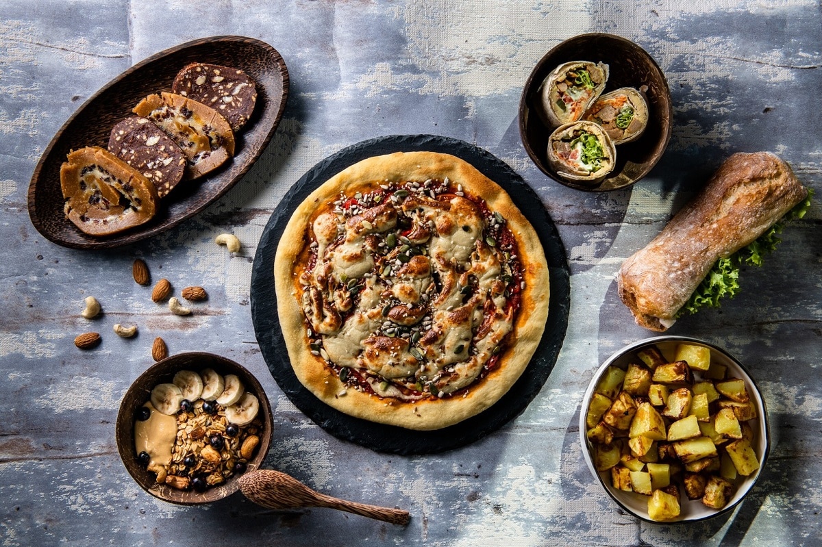 fotografie de sus cu farfurii negre pe fundal gri, in care sunt diverse preparate vegetariene de la Unison Plant Based Food din București