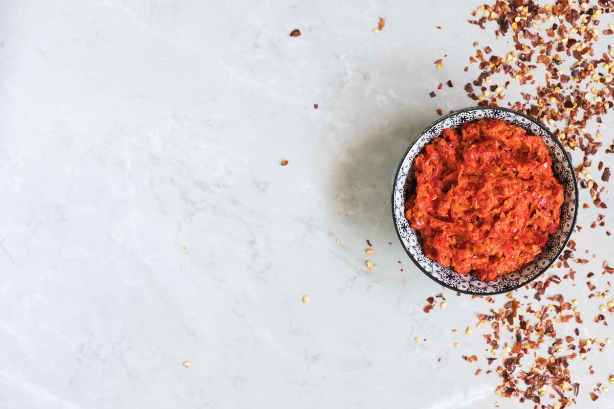 sos tradițional magrebian, cu ardei iute tocat, sambal, pe fundal de marmura gri. Sos din bucataria araba, unul dintre cele mai populare sosuri din lume