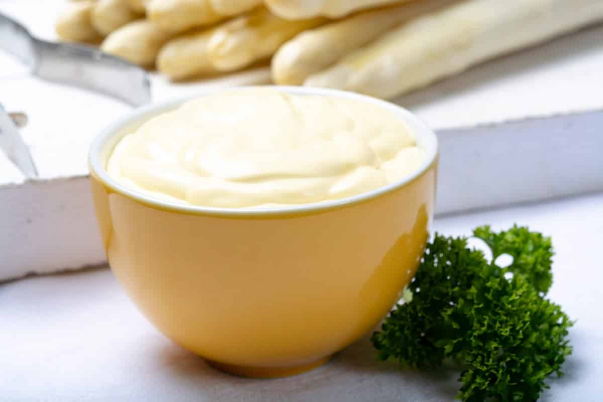 Sos Hollandaise in bol galben, sos traditional pentru preparatele cu sparanghel, close up 