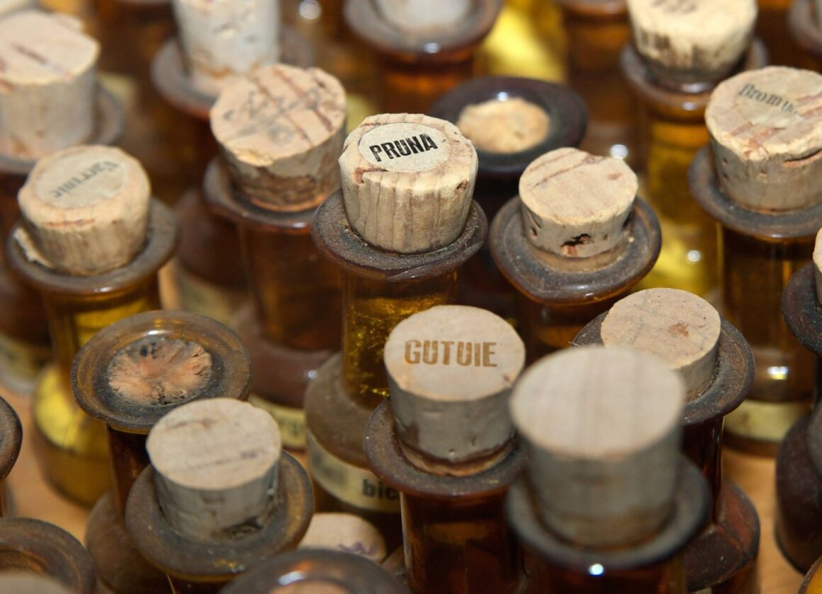 closeup cu multe sticle fotografiate de sus, cu dopuri de pluta, pe care scrie țuică sau palincă