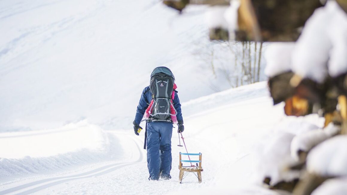Un barbat cara sania la deal pe partia inzapezita de sanius din Breitenstein, din satul Fischbachau;