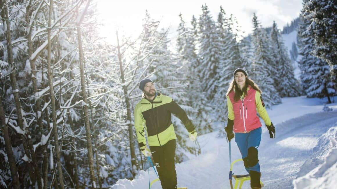 Un cuplu se bucura de zapada pe partia inzapezita de sanius din Breitenstein, din satul Fischbachau, Germania