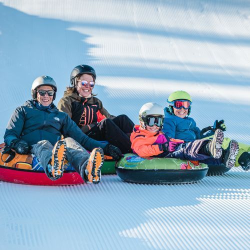 o familie se distreaza pe partia de sanius din Alpii francezi, in apropiere de statinea La Clusaz 