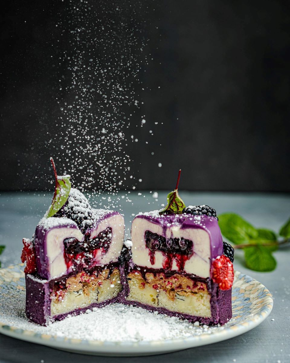 un desert cu fructe de padure sectionat median și pudrat cu zahar