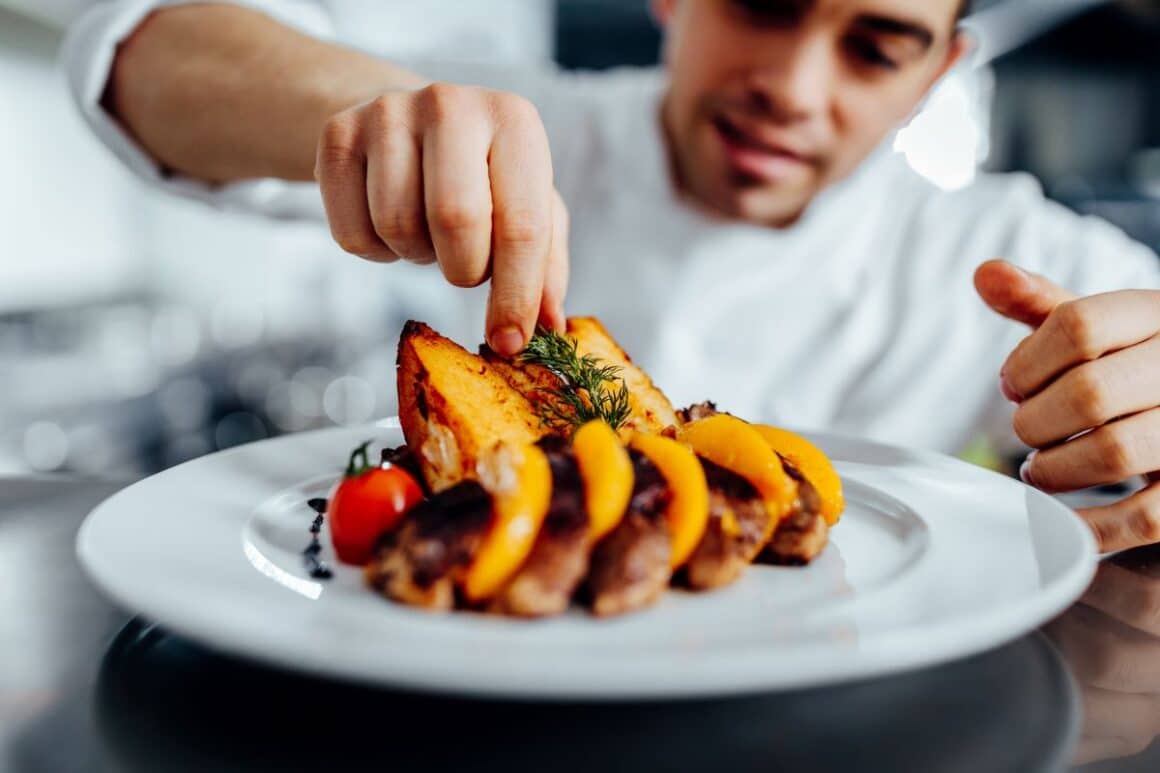 un bucatar decoreaza o farfurie gătită în jurul gustului umami