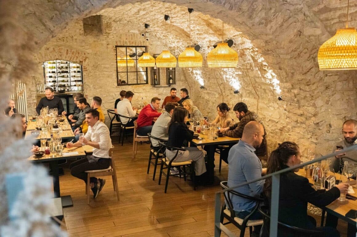 oameni care iau masa la restaurant Nativ din Cluj, amenajat intr-o crama cu pereti  din caramida - restaurante farm to table