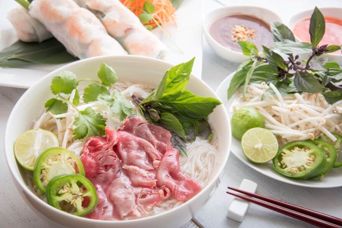 Un bol de Pho cu carne de vita alaturi de alte preparate tipic vietnameze. Preparate din jurul lumii