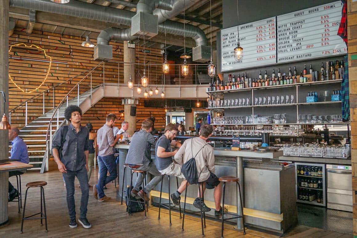 barbati care stau la bar intr-un pub industrial 