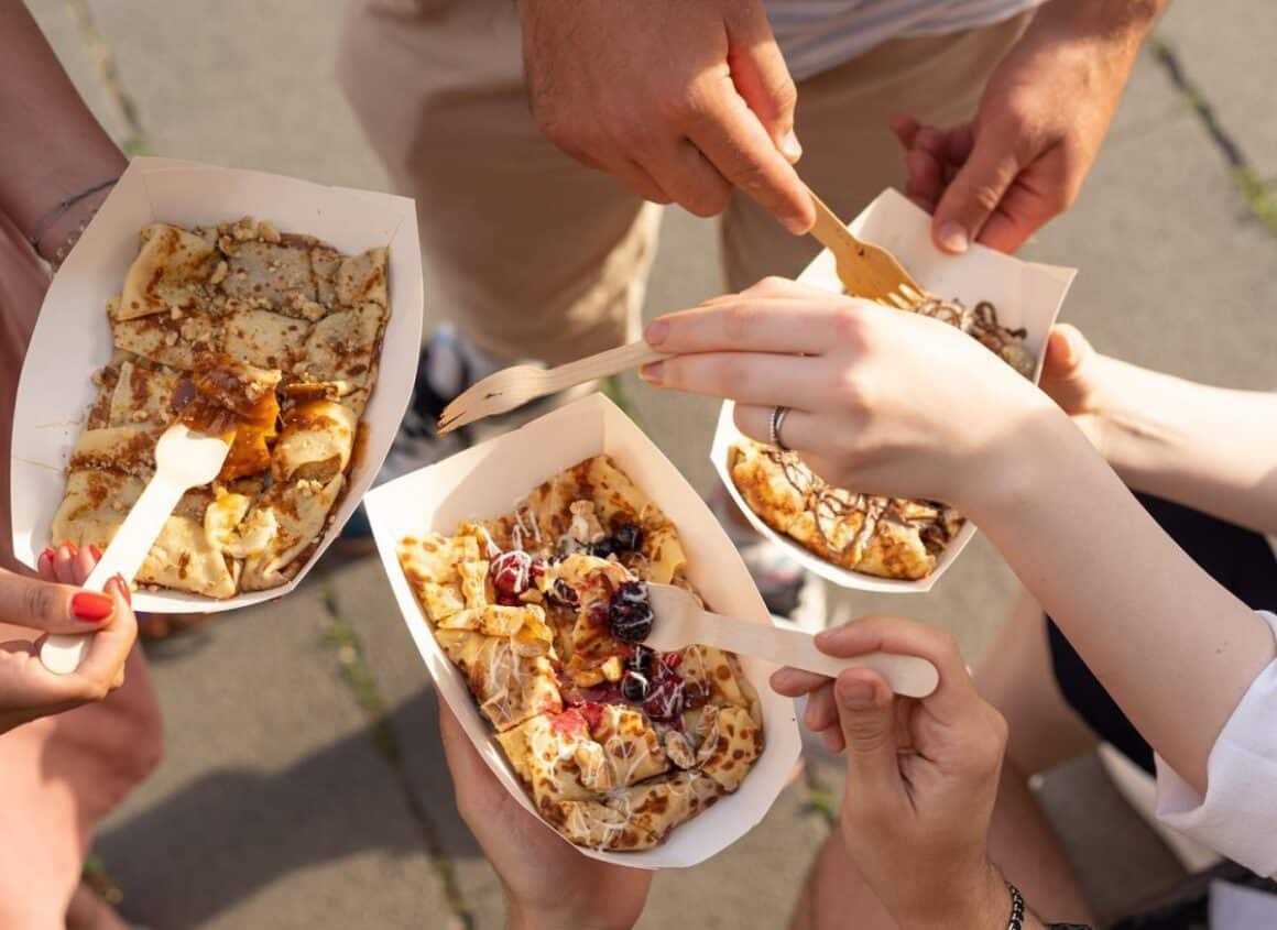 close up cu 3 cutii de carton cu clatite de diferite sortimente, din care 3 oameni mananca cu furculita, la Clateatarie, loc unde mâncăm clătite bune în București