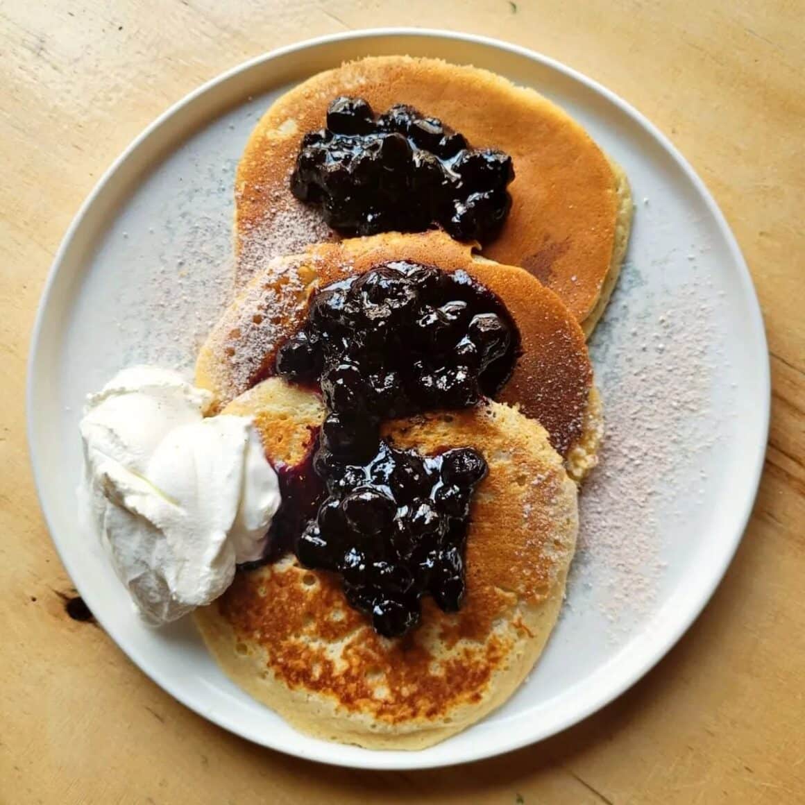 3 cltite americane cu dulceata si ricotta, fotografiate de sus, in farfurie la Jai Bistro, loc unde mâncăm clătite bune în București