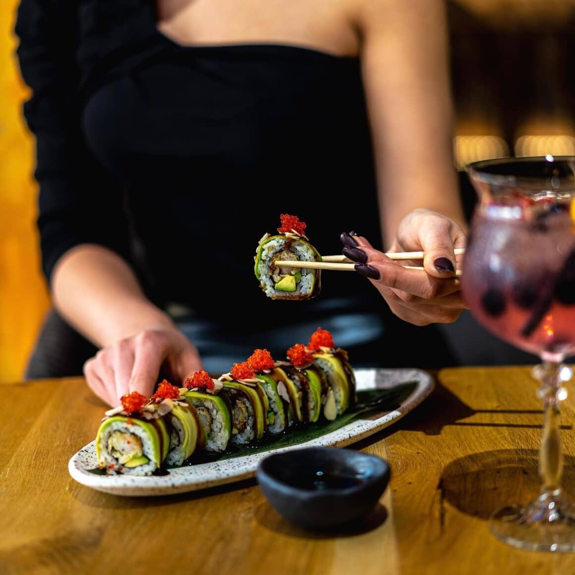 close up cu o femeie care serveste rulouri de sushi dint-run platou de la resturant Kitaro, restaurante Oradea