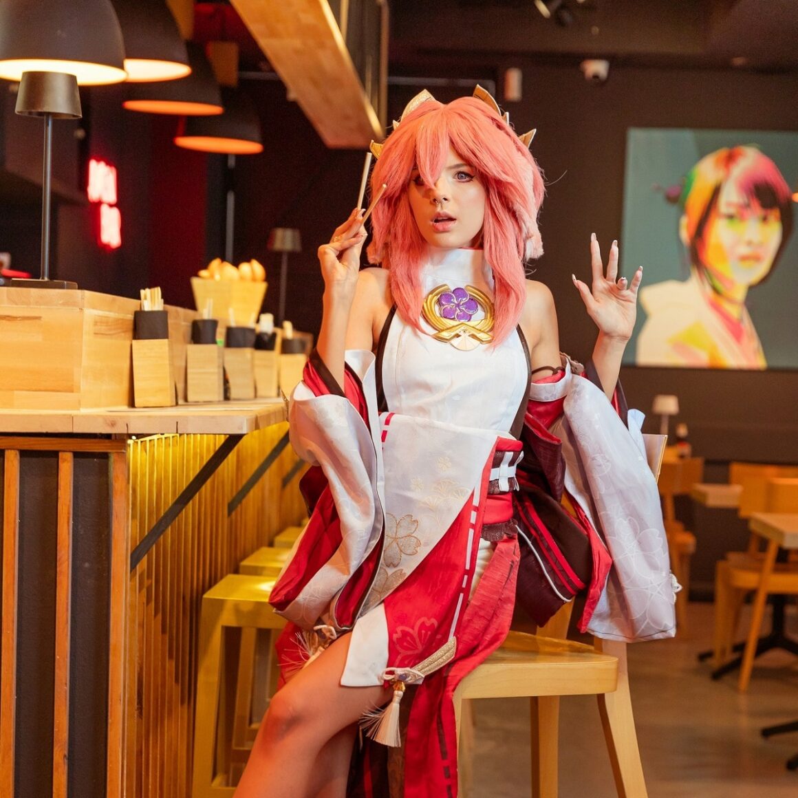 femeie cu peruca roz si costumatie mannga, asezata la bar la restaurant Japanos București