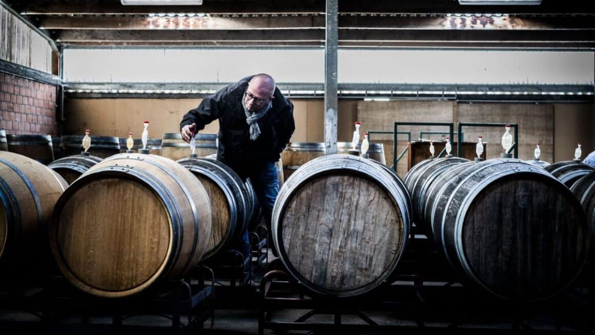 barbat care verifica butoaiele din lemn, oline cu bere, la Struise Brouwers - berării Belgia