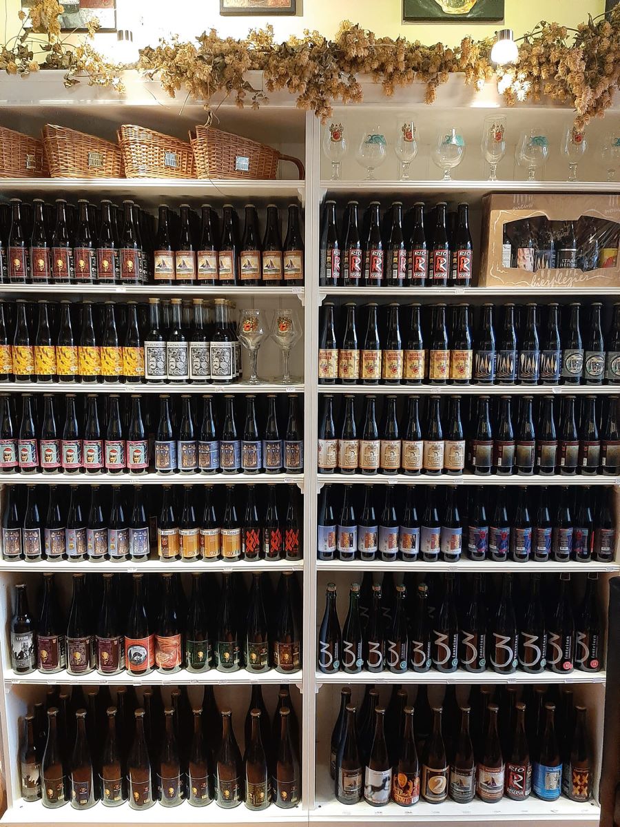 rafturi pline cu sticle de bere belgiană