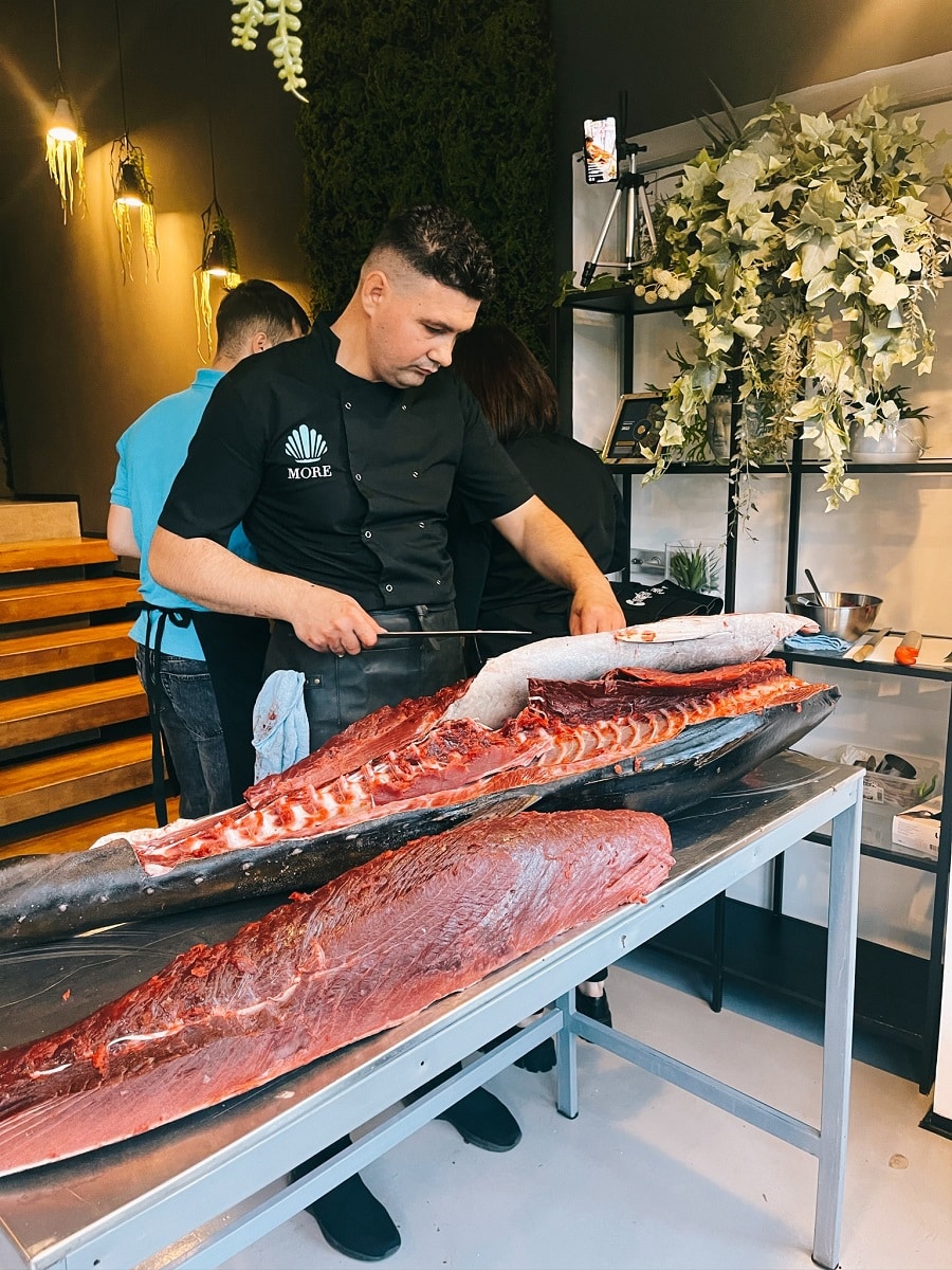 bucatar care portioneaza un peste ton foartea mre, la More Sushi - restaurante japoneze București
