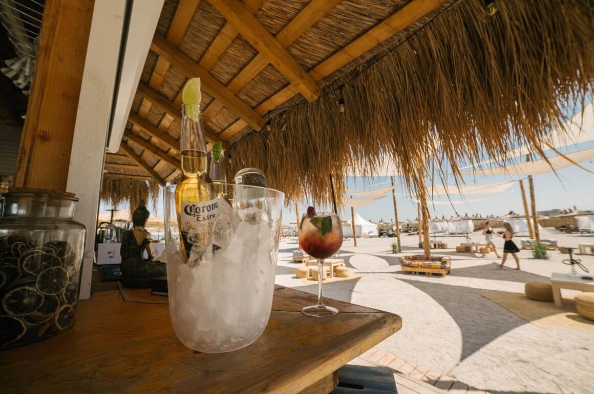 prim plan cu o frapiera si un pahar de cocktail, sub un acoperis cu stuf la restaurant IpaNera din Mamaia