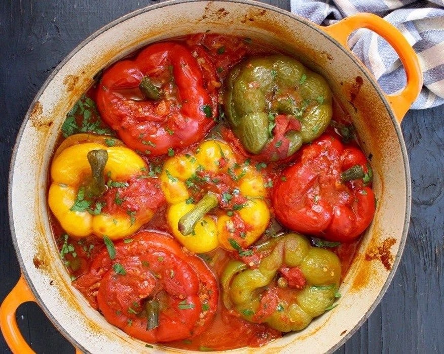 ardei grasi umpluti, de post, rosii, galbeni si verzi, in oala, fotografiati de sus.