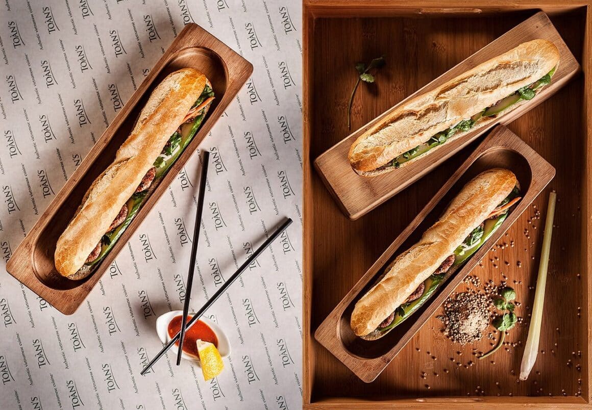 sandvisuri Banh Mi fotografiate de sus, in platouri de lemn. Sendvișuri celebre vietnameze.
