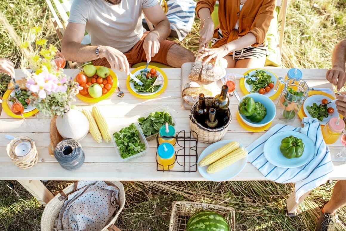 Top view a unor oameni care iau prânzul asezati la o masa lungă plina d emancare sanatoasa. Ce se întâmplă când ții post