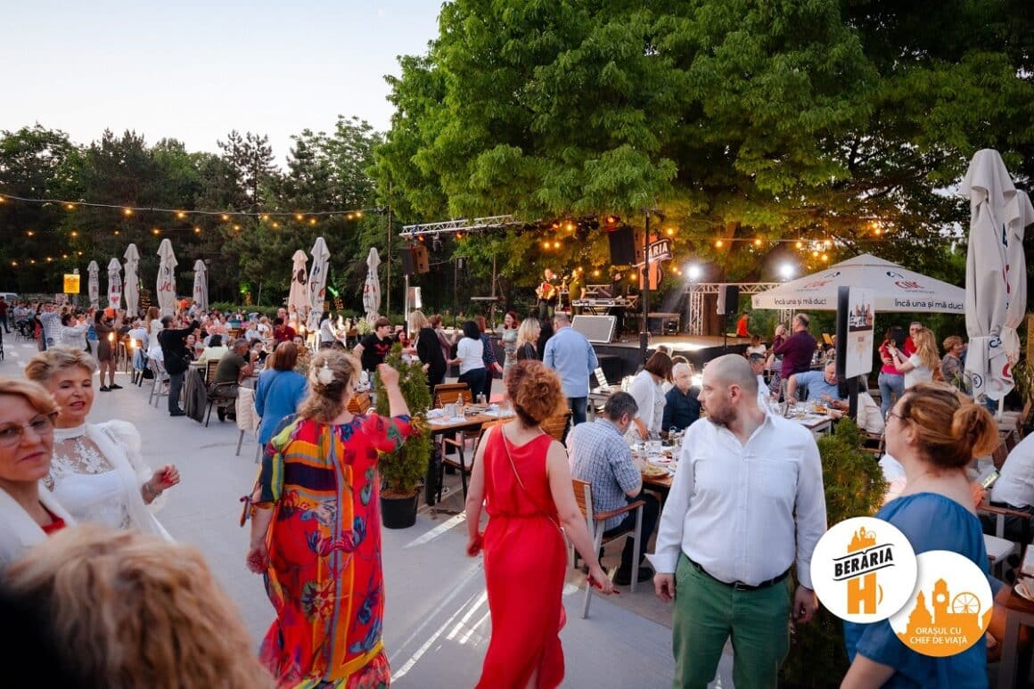 terasa plina de la Beraria H cu oameni la mese si o scena in fundal