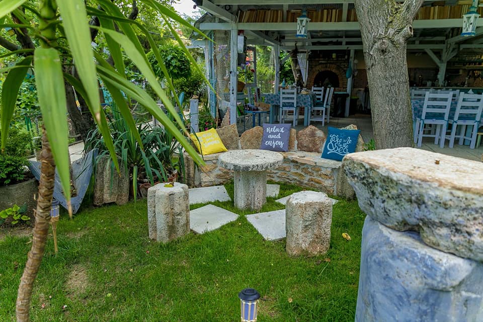 Masuta cu scaune din piatra in curtea de la Hacienda camping 2 mai