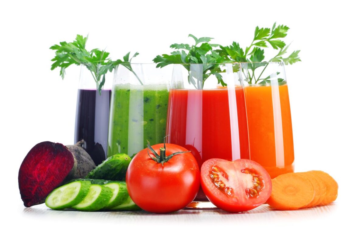 Mai multe pahare de sucuri naturale colorate și cateva legume taiate in jurul paharelor. Detox de primăvară