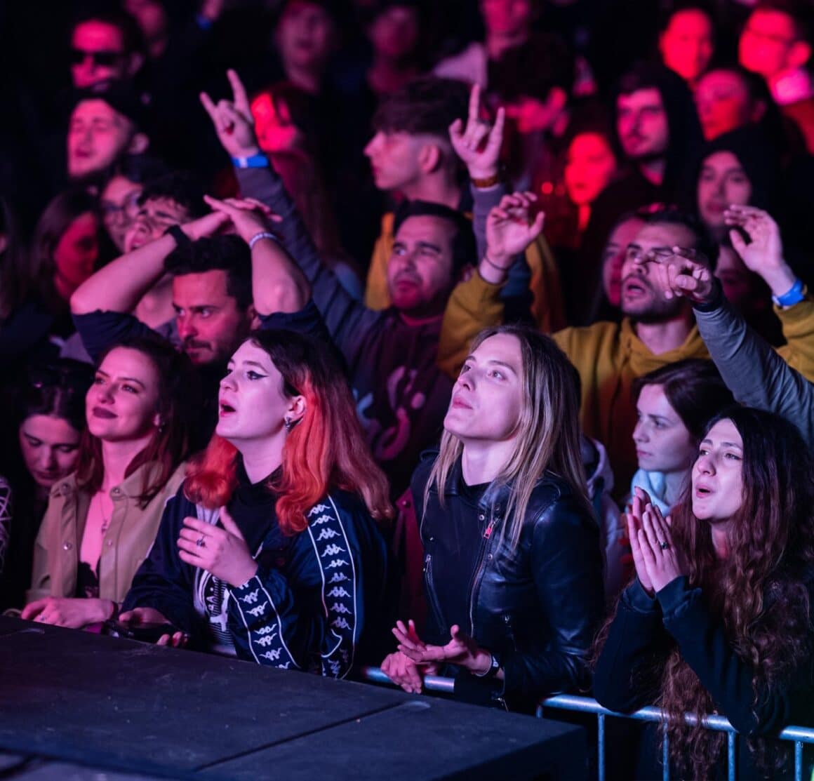 prim plan cu tineri in fata scenei la un concert de rock