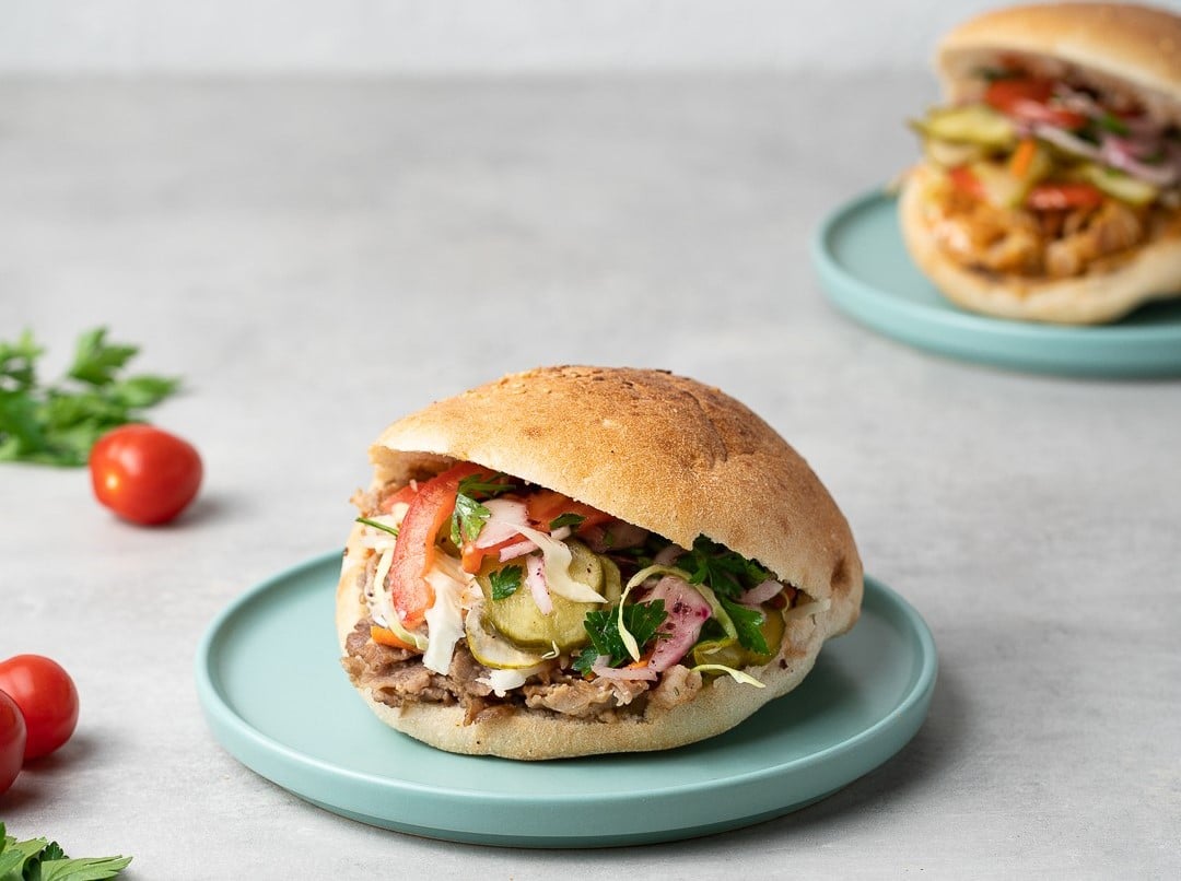 Tombik cu carne de viţel de lapte, salată de varză, salată de ceapă cu pătrunjel şi sumac, roşii, castraveţi muraţi, sos mediteranean, sos anatolia și ketchup, de la DonerBoom.