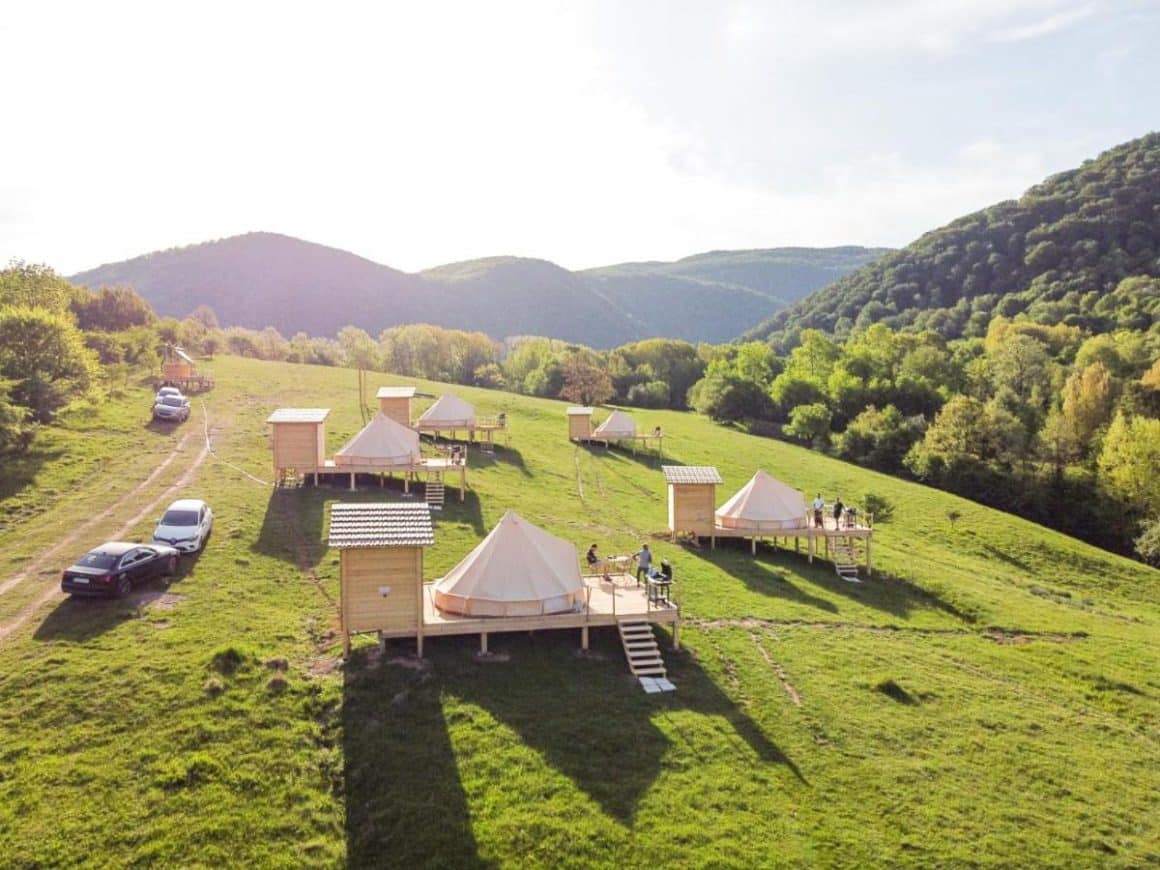 corturi de glamping rasfirate pe o pajiste la munte la The Hundetrs Glamping