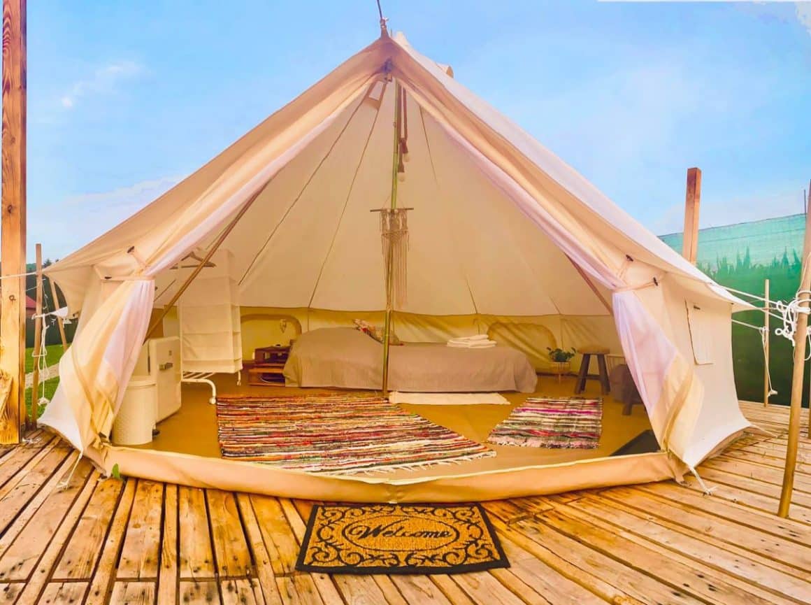 cort de glamping în România, Spiritul Zimbrului. un cort mare, deschis, amenajat confortabil cu pat, dulapioare si covoare 