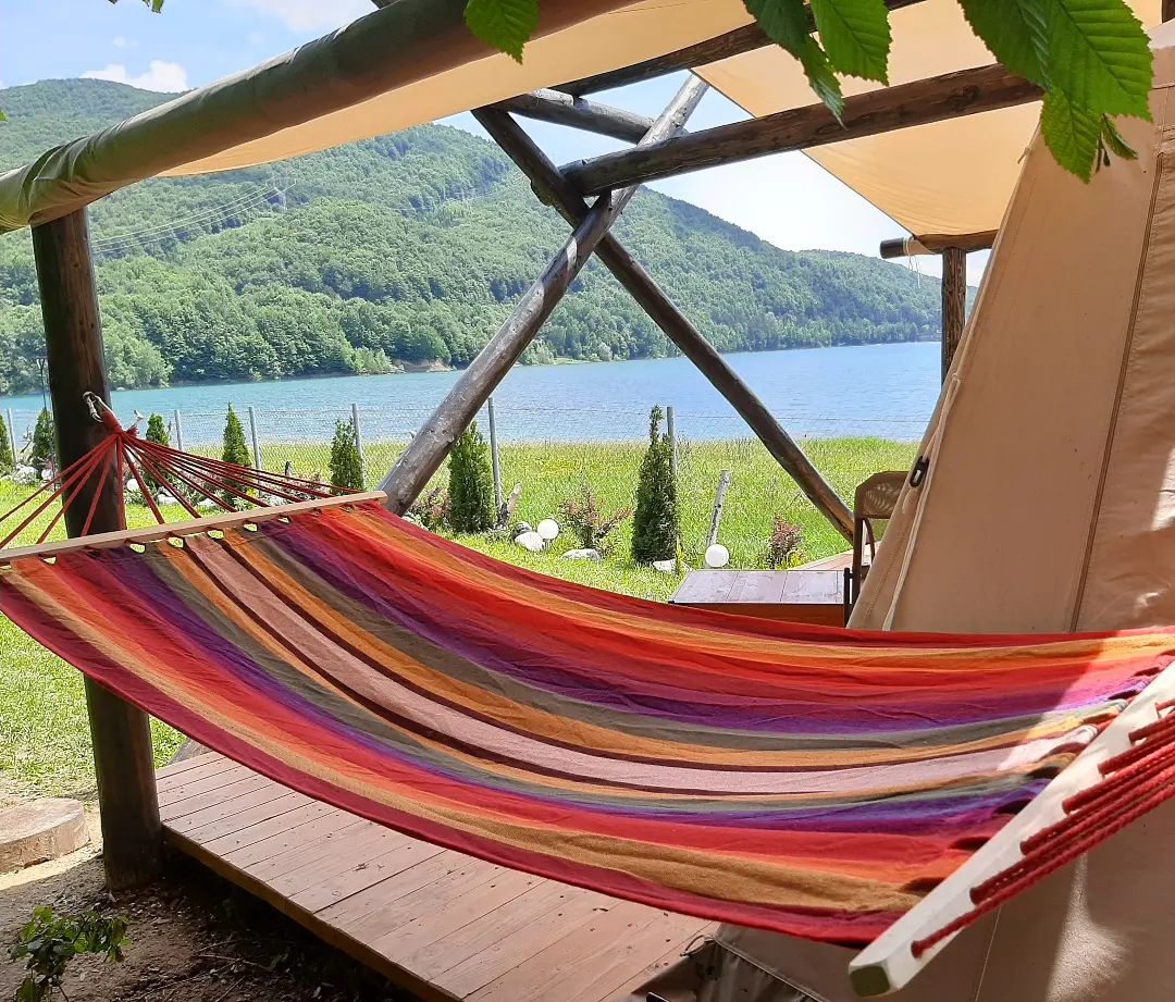 hamac amplasat pe terasa unui cort de glamping cu vedere la lac la Luxury Lake House & Glamping Teșila