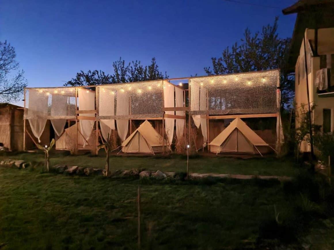 3 corturi de glamping amplasate fiecare  intr-un cadru de lemn, si in fata lor gazon la SupVamaVeche