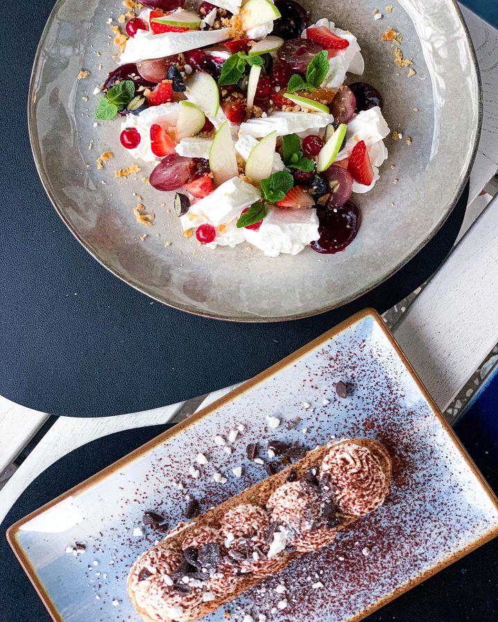 2 farfurii cu tiramisu si pavlova, fotografiate de sus, la Ergo Restaurant. Noutăți în meniurile restaurantelor primăvară 2023