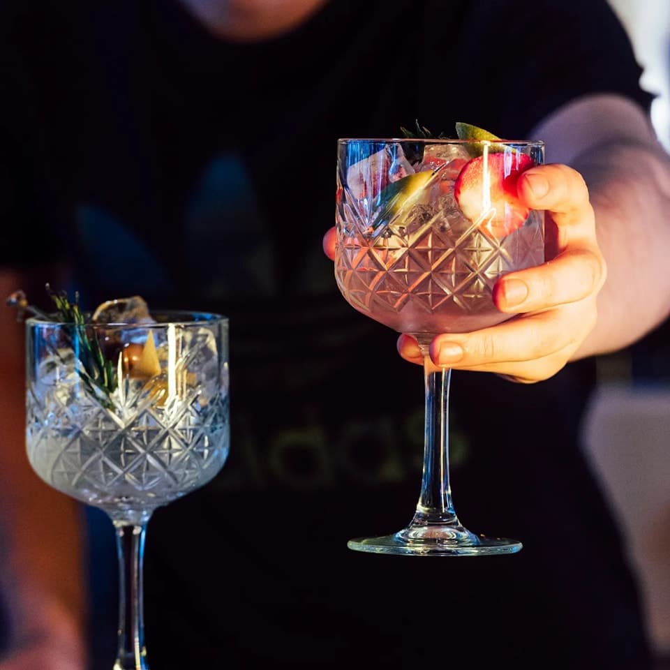 2 pahare cu gin servite de un barbat