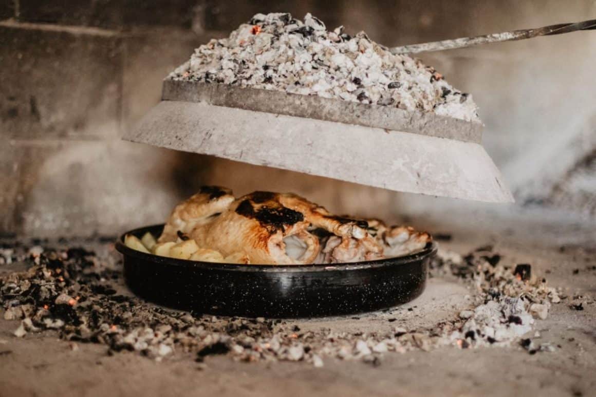 o portie de peka cu pui scoasa de sub carbunii incinsi