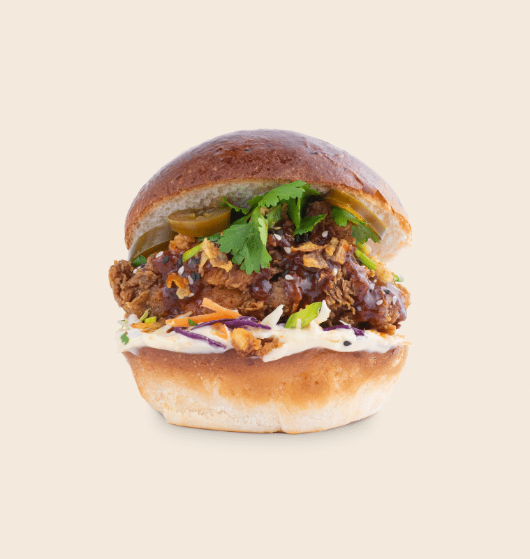 Korean burger de la Le Bab Fried Chicken close up pe fundal roz, Burgeri gustoși în București