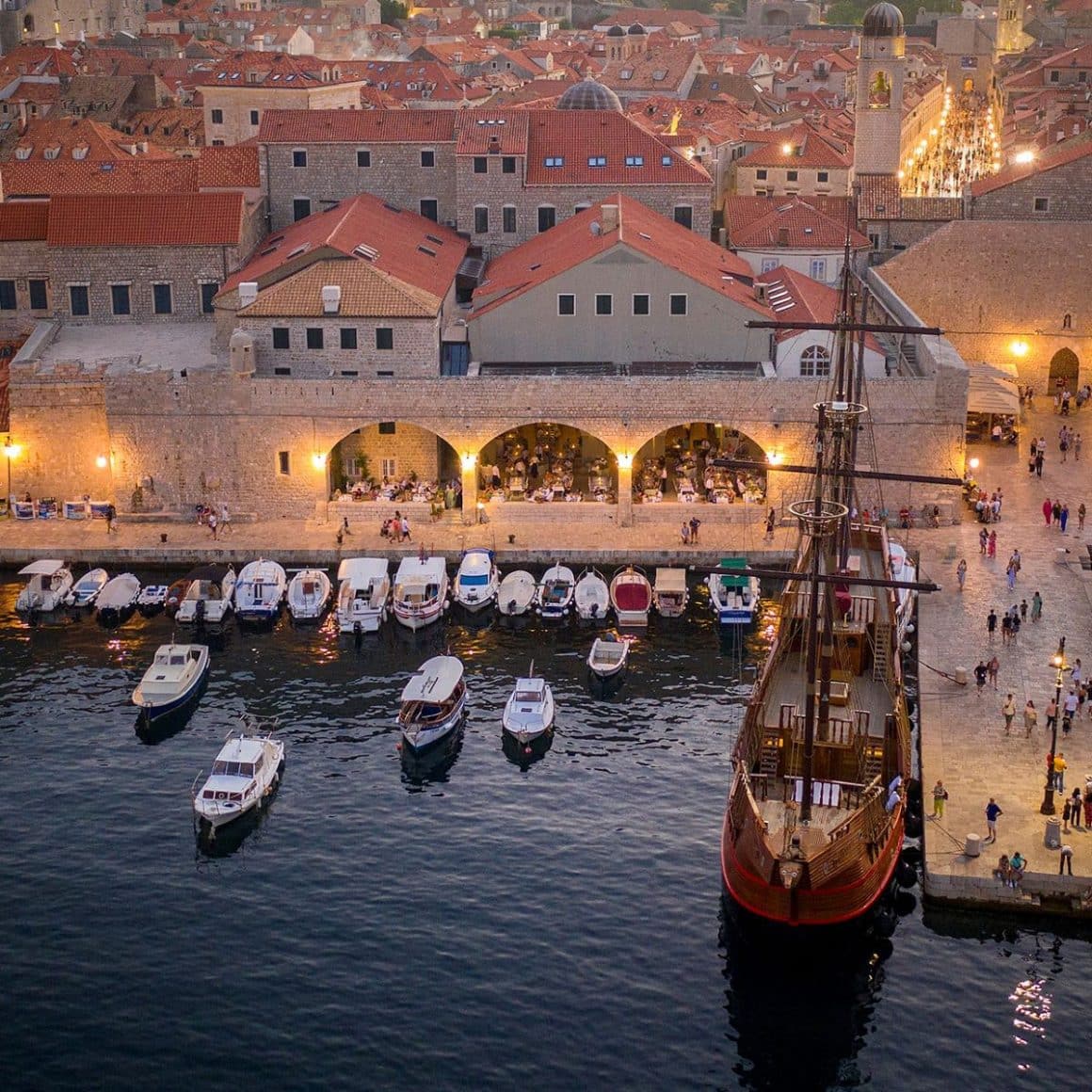 Terasa restaurantului Gradska Kavana Arsenal, pe maulul apei, cu barcute andocate. Fotografie de sus, de la distanță. Unde am mâncat în Dubrovnik
