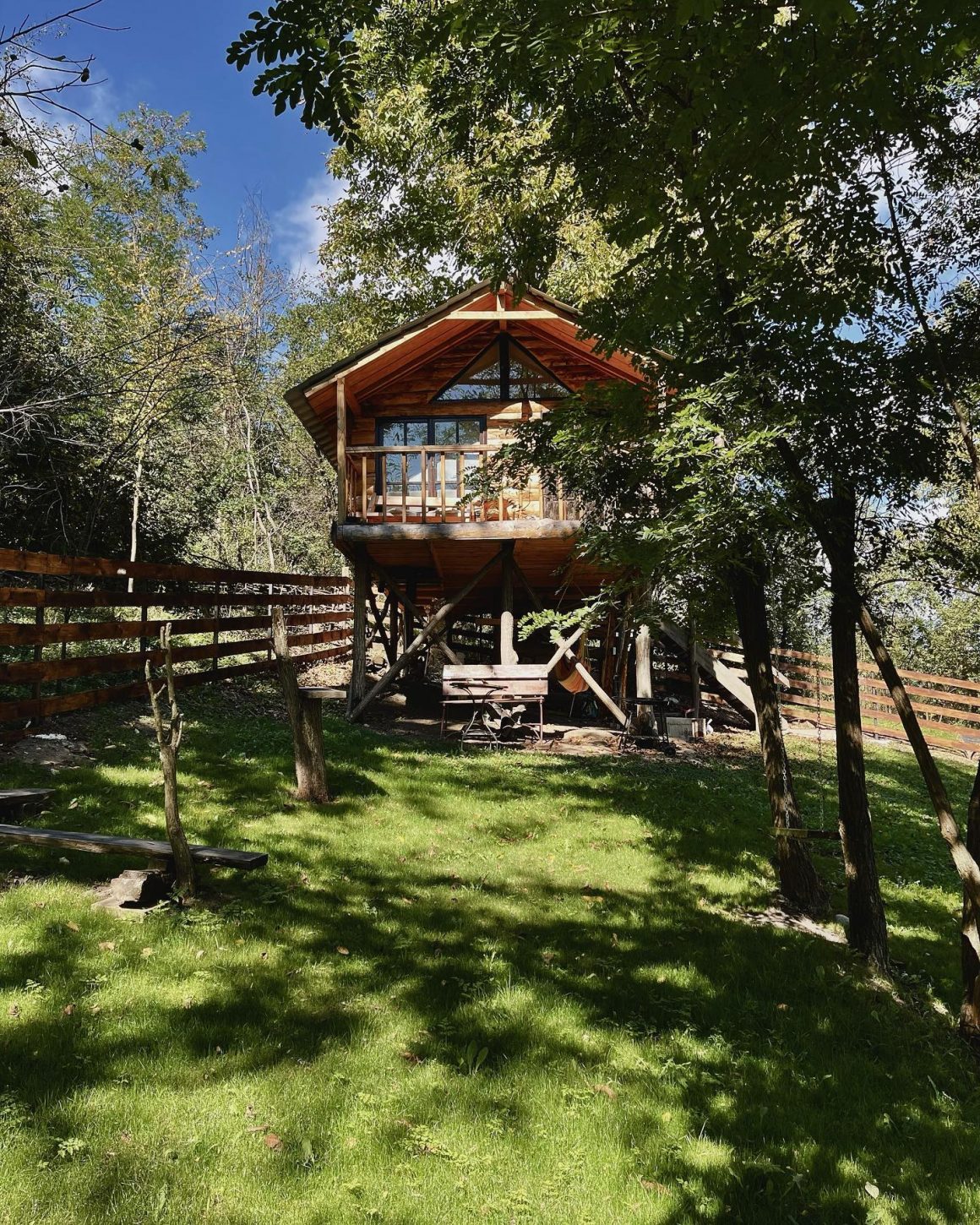 fotografie de la distanta cu Transylvania Loft Treehouse, vara, printre copaci. Căsuțe în copac