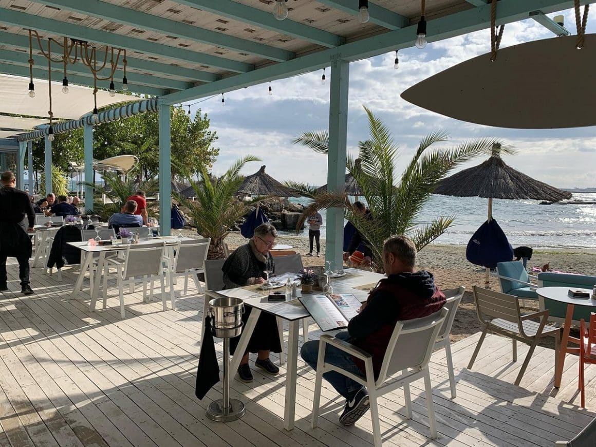 oameni care iau masa pe terasa acoperita de la Golful Pescarilor Agigea
