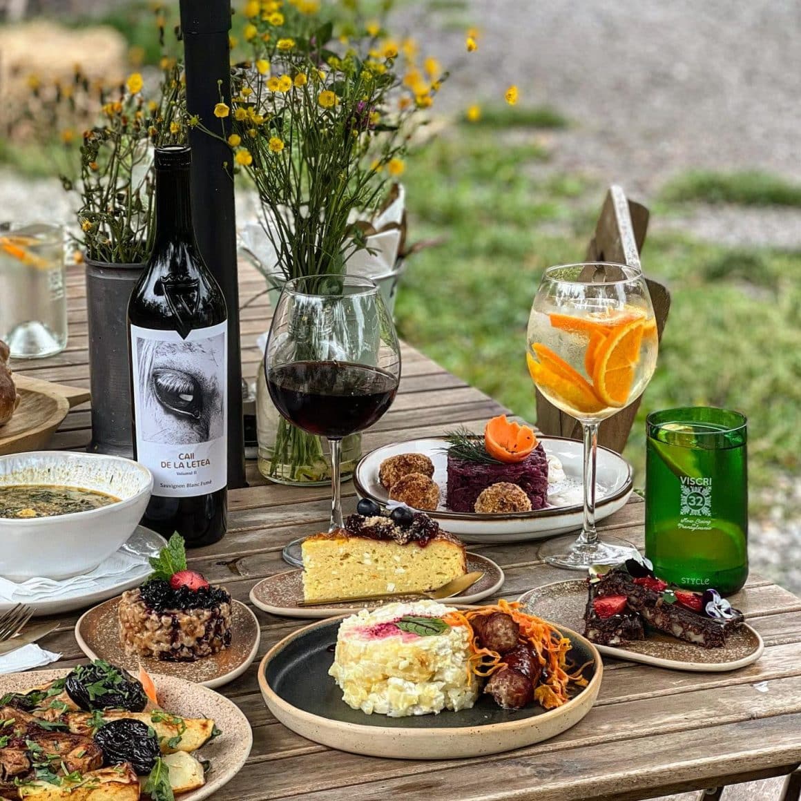 masa cu preparate culinare romanesti si pahare din vin la Viscri 32