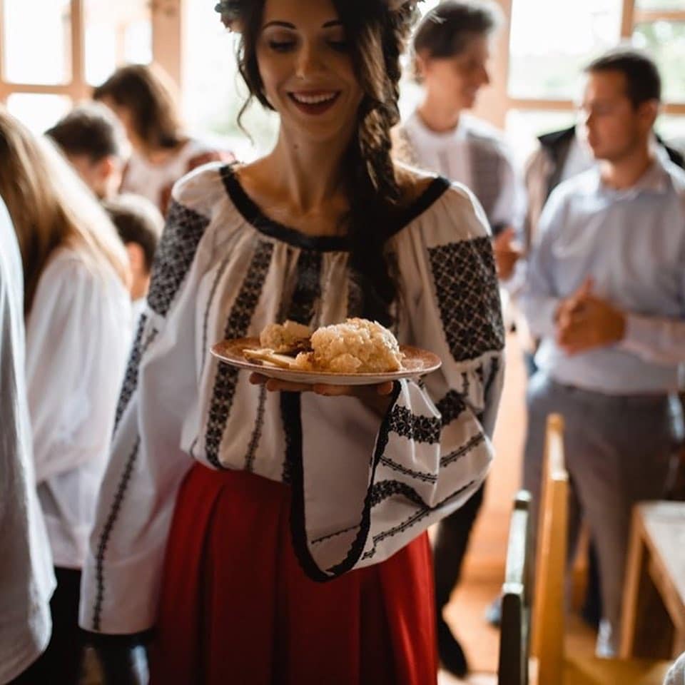 Femeie imbracata in ie serveste masa la Viscri 32