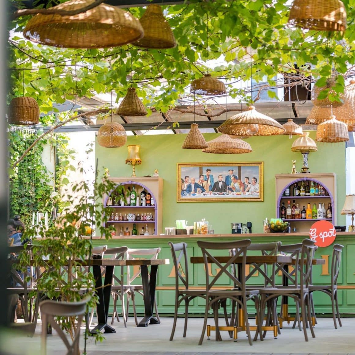 terasa de la Gspot Sufrageria, cu mese si scaune clasice si curte acoperita de vita de vie, din care atarna mai multe lustre moderne, iar in final barul cu aspect rustic